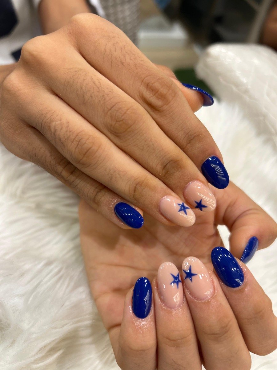 Glossy blue nail art with star accents
